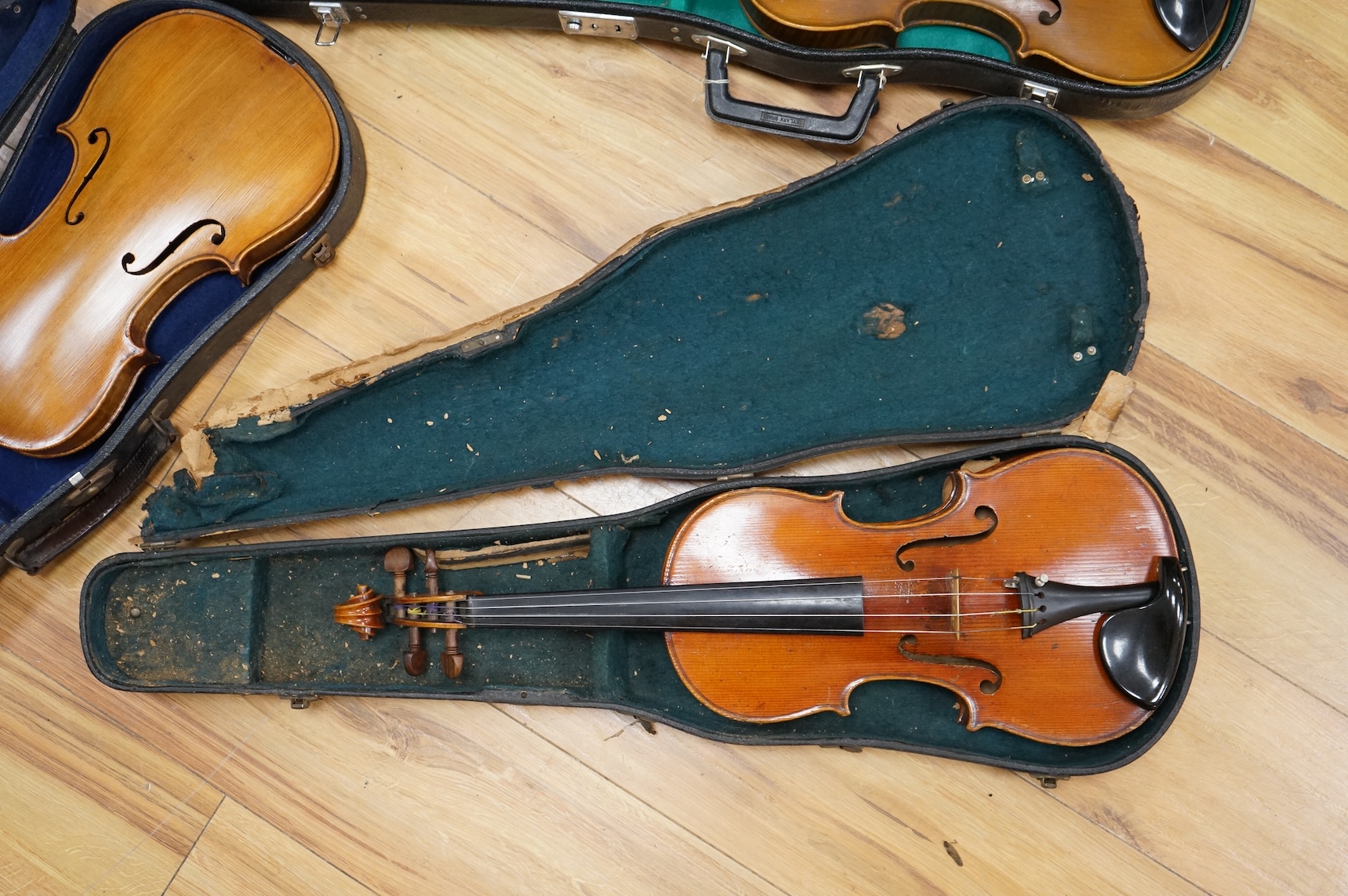 Three cased violins; a German Dresden violin, supplied by Campbell and co., Glasgow, together with another Dresden Stradivarius copy, and the remains of a European violin.